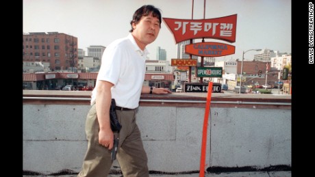 Store owner Richard Rhee stands vigil, armed with a handgun and a cellular phone on the roof of his grocery store in the Koreatown area of Los Angeles on May 2, 1992.