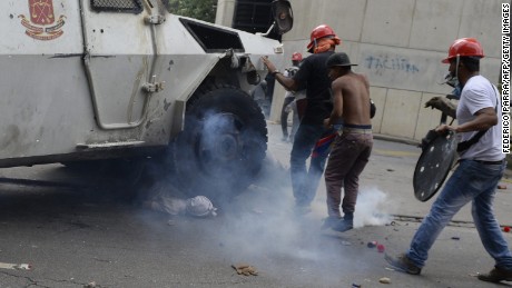 Protesters watch as an armored truck runs over Yaminne. 