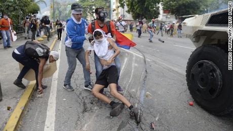 Yaminne is dragged to safety after being run over by an armored vehicle. 