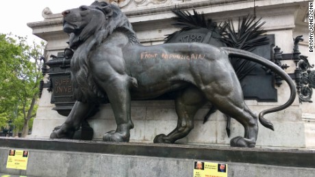 One of the lions at the base of the statue in Paris&#39; Place de la Republique has been defaced with graffiti. 