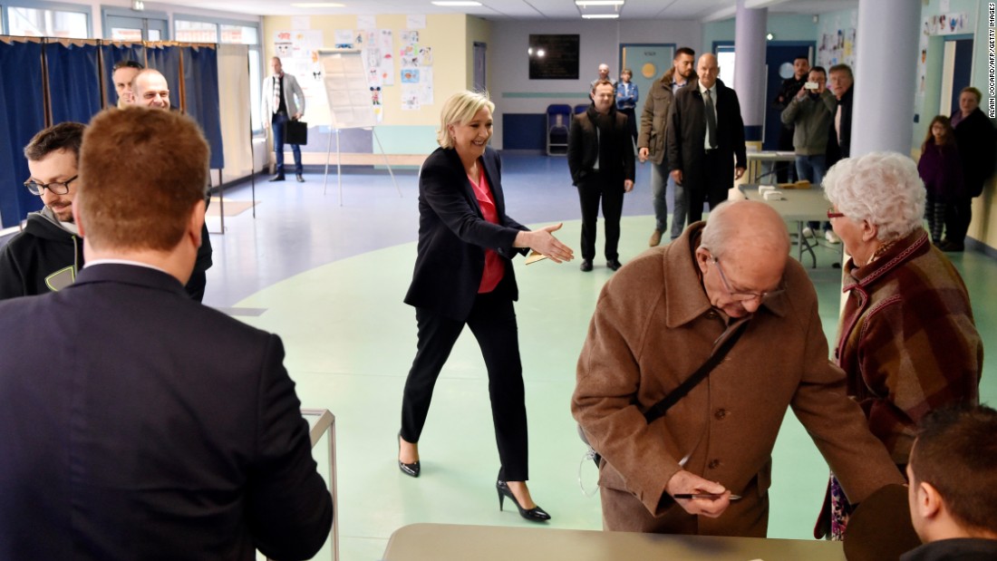 French presidential candidate Marine Le Pen moves to shakes hands with a woman at a polling station in Henin-Beaumont, France, Le Pen&#39;s home town.  