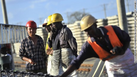 African, right, and Chinese workers, left, build railway track sections for the Mombasa-Nairobi Standard Gauge Railway (SGR) line in Tsavo, Kenya.