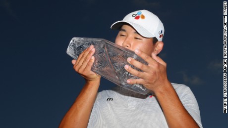 Kim Si Woo of South Korea celebrates with the winner&#39;s trophy after the final round of the 2017 Players Championship.