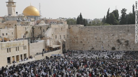 Jewish people take part in the Cohanim prayer (priest&#39;s blessing) during the Passover (Pesach) holiday at the Western Wall in the Old City of Jerusalem on April 13, 2017, with the Dome of the Rock seen in the background. 