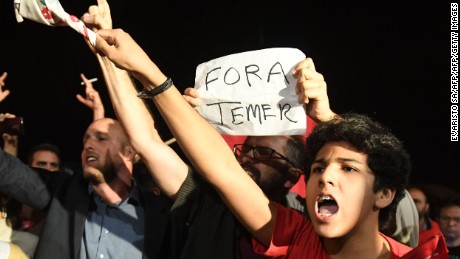 Demonstrators protest against Brazilian President Michel Temer outside the Planalto Palace in Brasilia on May 17, 2017.
Temer was secretly taped by one of the owners of J&F Investimentos - the family holding company that controls the JBS meat processing company - giving the green light to a bribery scheme to keep Cunha quiet, the Brazilian newspaper O Globo reported on May 17, 2017. / AFP PHOTO / EVARISTO SA        (Photo credit should read EVARISTO SA/AFP/Getty Images)