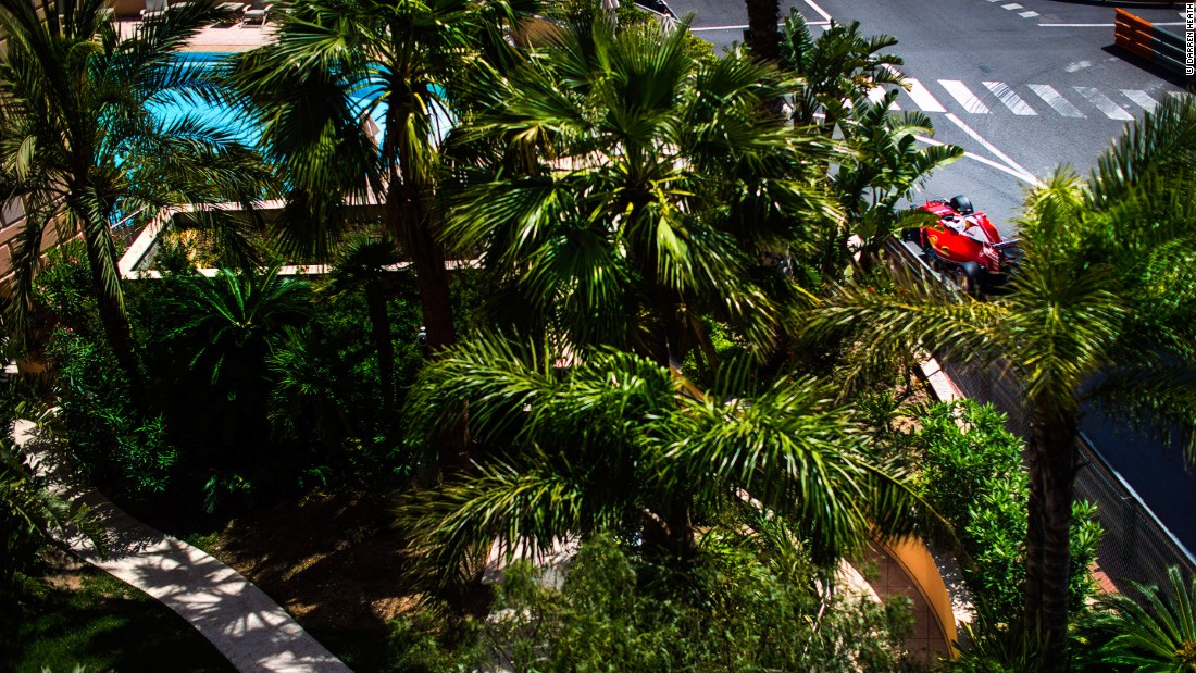 Ferrari&#39;s Kimi Raikkonen glimpsed through the palm trees lining the track.