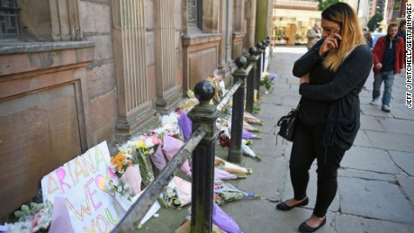 A woman looks emotional as she looks at flowers left in St Ann Square on Tuesday, May 23, 2017 in Manchester,England. At least 22 people were killed in a suicide bombing at a pop concert packed with children in the northern English city of Manchester, in the worst terror incident on British soil since the London bombings of 2005.