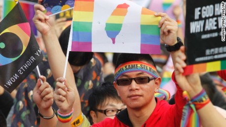 A supporter of LGBT and human rights holds a rainbow flag with Taiwan map during a rally supporting a proposal to allow same-sex marriage in Taipei, Taiwan, Saturday, Dec. 10, 2016. 