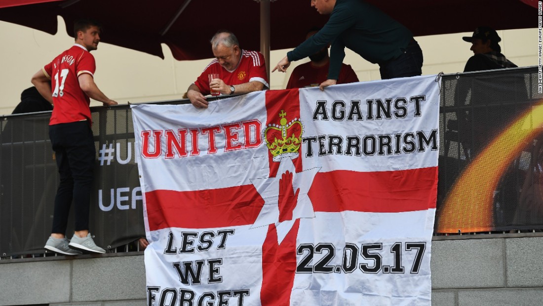 United fans put up a flag in memory of the victims of the Manchester terror attack.