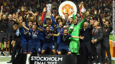 Club captain Wayne Rooney lifts trophy as United&#39;s players celebrates a first Europa League title for the club 