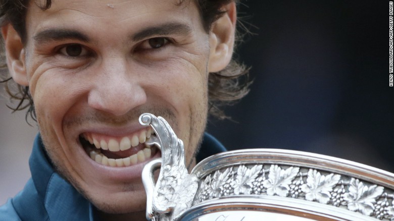 Spain's Rafael Nadal bites the Musketeers trophy after winning the 2013 French tennis Open final against Spain's David Ferrer at the Roland Garros stadium in Paris on June 9, 2013. 
