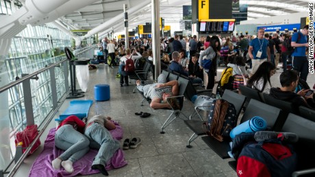 People sleep on a blanket at Heathrow Airport Terminal 5 on May 28, in London, England. Thousands of passengers face a second day of travel disruption after a British Airways IT failure caused the airline to cancel most of its services. 