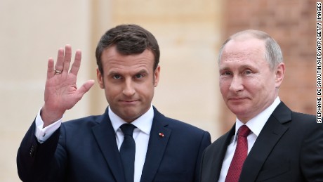 French President Emmanuel Macron welcomes Russian President Vladimir Putin at the Versailles, near Paris, on Monday.

