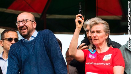 Belgian Prime Minister Charles Michel reacts as Princess Astrid of Belgium fires a starter&#39;s pistol signaling the start of a 20K road race Sunday in Brussels. 