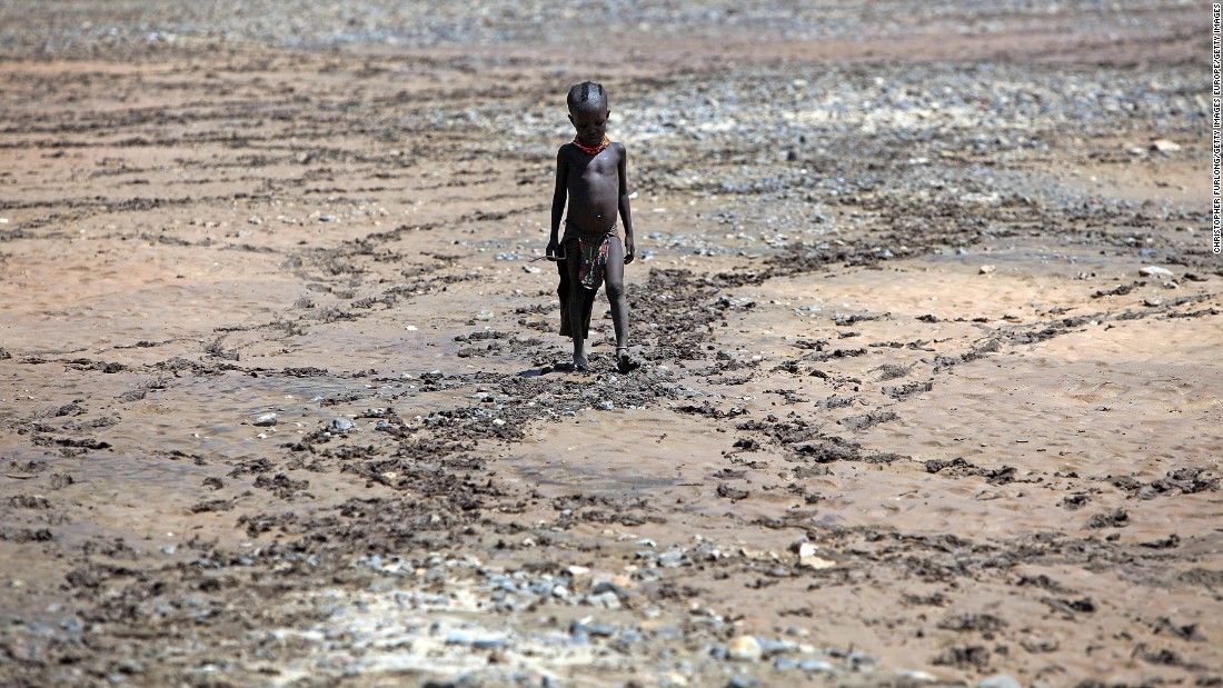 A boy from the remote Turkana tribe in Northern Kenya walks across a dried up river near Lodwar, Kenya. Millions of people across Africa are facing a critical shortage of water and food, a situation made worse by climate change. 