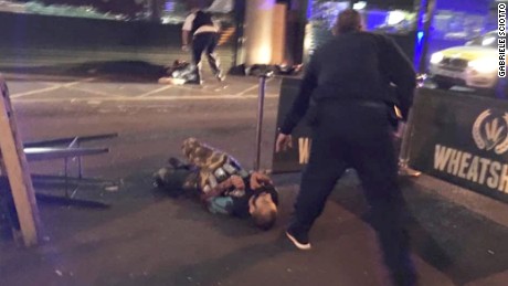 Image from London&#39;s Borough Market shows two people lying on the road. Police activity is visible nearby.