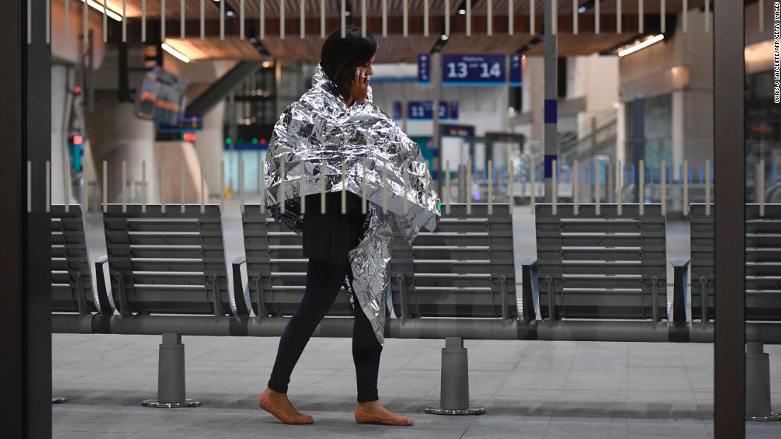 A woman wearing an emergency blanket talks on her phone at London Bridge train station. London Bridge Tube station was closed and London Bridge was closed in both directions.