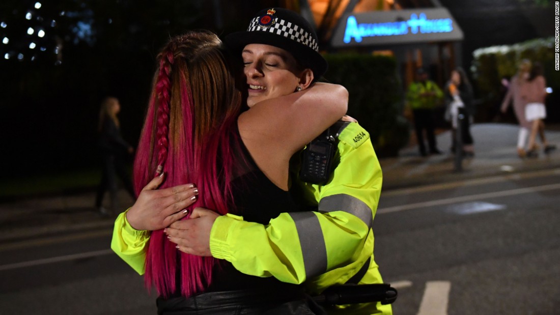 A music fan hugs a police officer as fans leave Old Trafford Cricket Ground after the benefit concert for the families of the victims of the May 22, 2017 Manchester terror attack. 