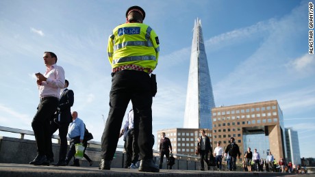 Commuters walk past a police officer on London Bridge in London, Monday, June 5. 