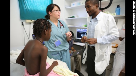 Drs. Jennifer Rutledge e Jeanty Elise falam com uma menina de 11 anos que está doente com doença cardíaca congénita.