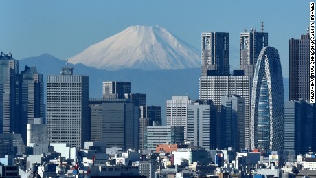 Japan&#39;s highest mountain, Mount Fuji (C) is seen behind the skyline of the Shinjuku area of Tokyo on December 6, 2014. Tokyo stocks closed at a seven-year high on December 5 -- extending their winning streak for a sixth straight day -- as a falling yen and oil prices continue to boost investor spirit.  AFP PHOTO / KAZUHIRO NOGI        (Photo credit should read KAZUHIRO NOGI/AFP/Getty Images)