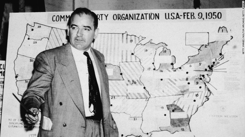 Joseph McCarthy, a Republican senator from Wisconsin, stands before a map which charts Communist activity in the United States in 1954.