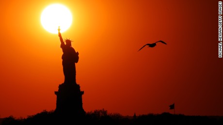 NEW YORK, NEW YORK - JUNE 02: The sun sets behind the Statue of  Liberty as a seagull flies past on June 02, 2017 in New York City. (Photo by Michael Heiman/Getty Images)