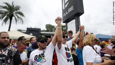 Le persone si tengono per mano lunedì 12 giugno, mentre partecipano a una cerimonia commemorativa al nightclub Pulse di Orlando. Una veglia è stata tenuta al club un anno dopo una sparatoria di massa lt;a href=quot;; target=quot;_blankquot;gt;ha rivendicato 49 vitelt;/agt; lì.