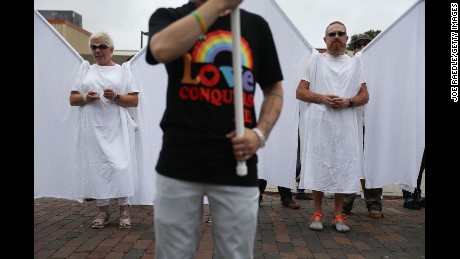 Mensen verkleed als quot;guardian angelsquot; wonen de herdenkingsdienst bij.