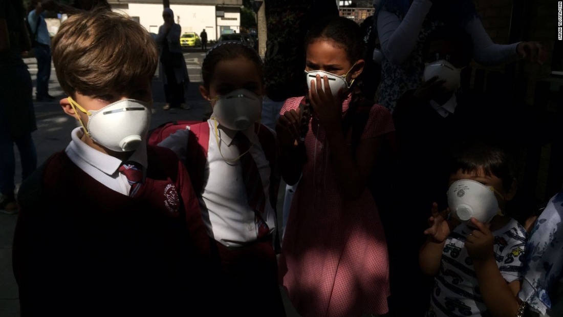 Children wear masks that were distributed near the site of the fire.