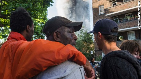 People comfort a man whose relatives lived in Grenfell Tower and hadn&#39;t yet been located since the fire.