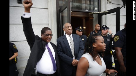 Andrew Wyatt raises his fist as Bill Cosby exits court after a mistrial was declared.