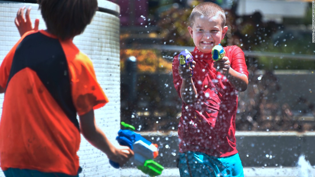Boys cool off with water guns in downtown Los Angeles on Monday, June 19.