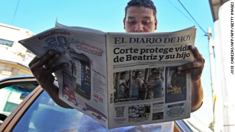A man reads a paper headlined: &quot;Court protects life of Beatriz and child.&quot; Beatriz, a chronically ill Salvadoran woman was denied an abortion in 2013, despite the fact her fetus was unviable.