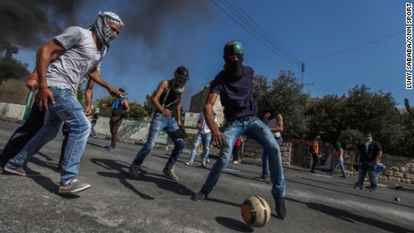 Taken in October 2016, this is a picture of masked Palestinian youths playing football at the main entrance of the West Bank city of Bethlehem.