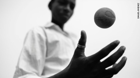 This photo is part of a project created by David Jimenez titled &quot;Omen.&quot; Here a young boy in India plays with a worn cricket ball. 