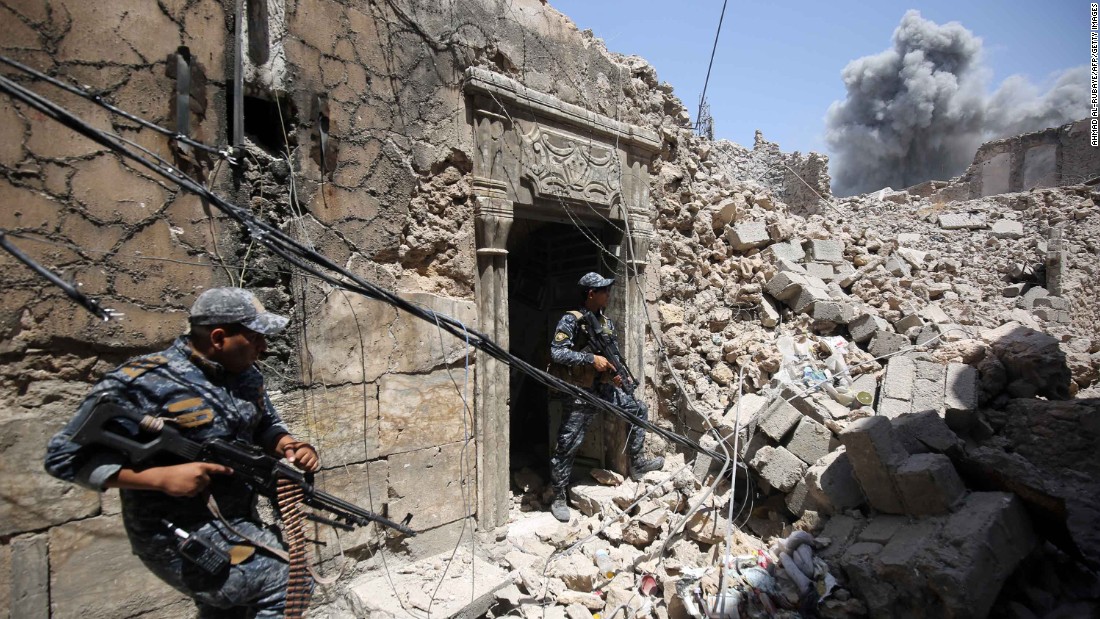 Members of the Iraqi Federal Police hold a position as US-led coalition forces advance through the Old City on Wednesday, June 28.