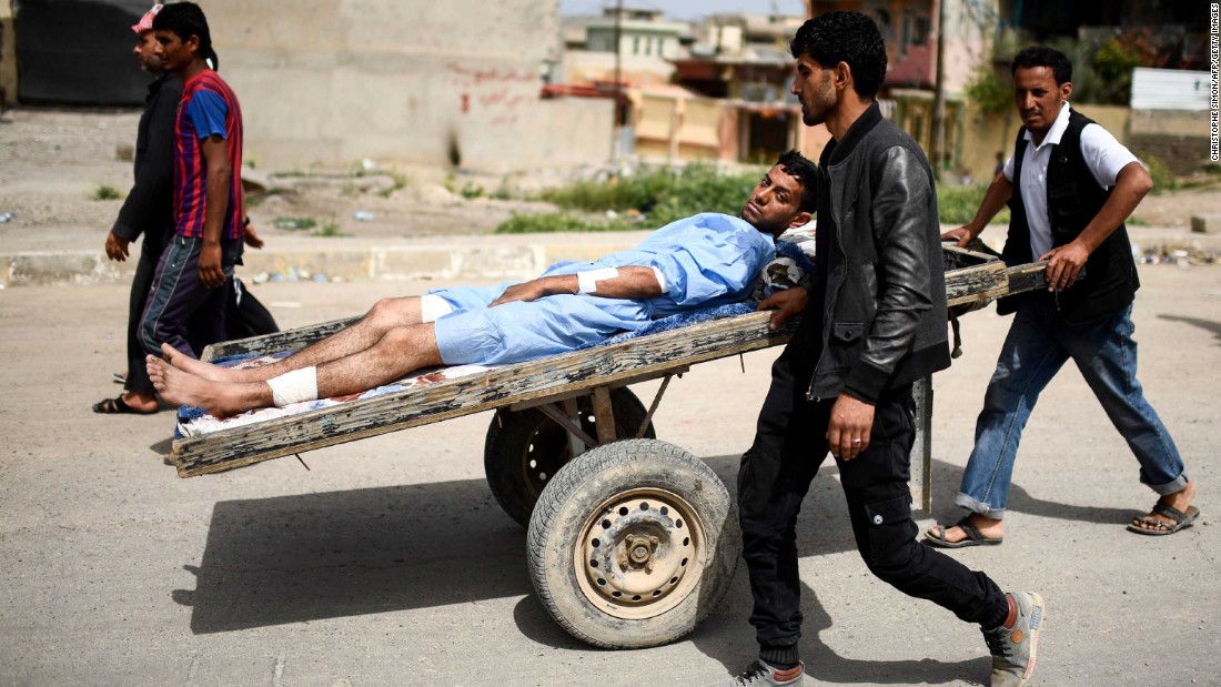 A wounded man is transported in western Mosul on Friday, April 21.