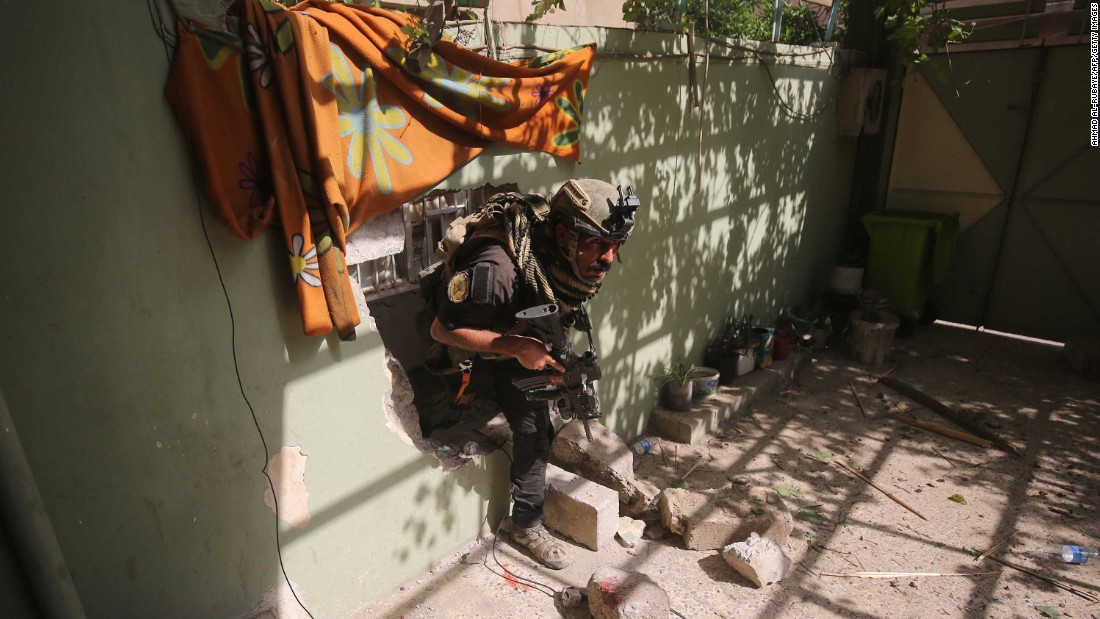 A member of the Iraqi counterterrorism service secures a building as troops push toward Mosul&#39;s Al-Oraibi western district on Sunday, May 14.