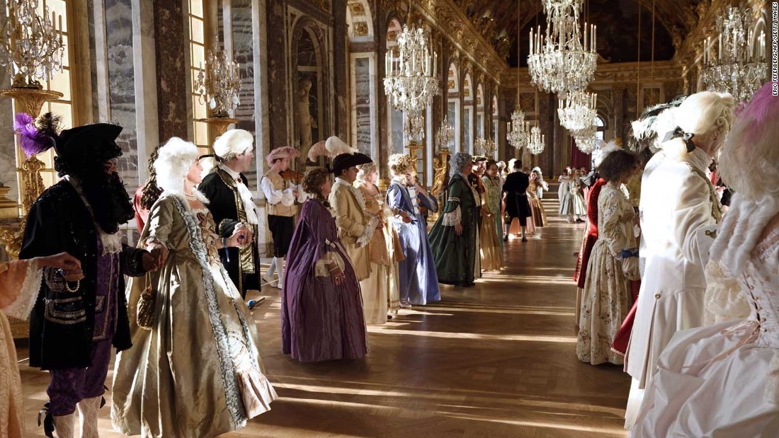 People dressed in period costumes learn dance moves in the Galerie des Glaces, or Hall of Mirrors, at Versailles.