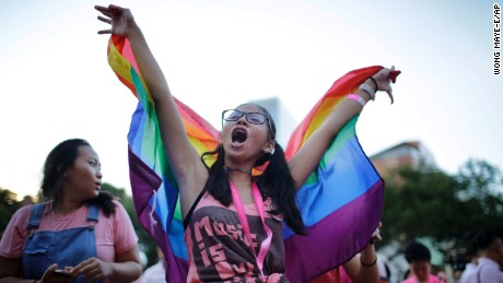 Student Ashleigh Ng, 15, waves a rainbow flag while singing along at a concert during Saturday&#39;s Pink Dot gay pride event.