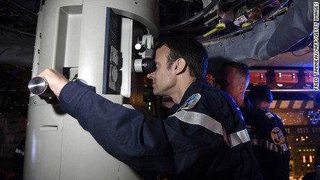 French President Emmanuel Macron looks through the periscope of submarine &quot;Le Terrible&quot; during a July 4, 2017 visit aboard the vessel. 
