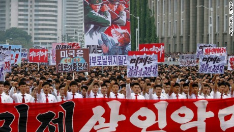 kymmenettuhannet miehet ja naiset pumppaavat nyrkkejään ilmaan ja laulavat quot; puolusta!quot; koska he kantavat julisteita anti-American propaganda iskulauseita pjongyangapos; s keski Kim Il Sung Square sunnuntai, kesäkuu 25, 2017, Pjongjang, Pohjois-Korea -- Vuosipäivä alkaa Korean Sodan. Pohjois-Koreassa itapos;s nimeltään quot; päivä taistelu Yhdysvaltain imperialismia vastaan.quot;