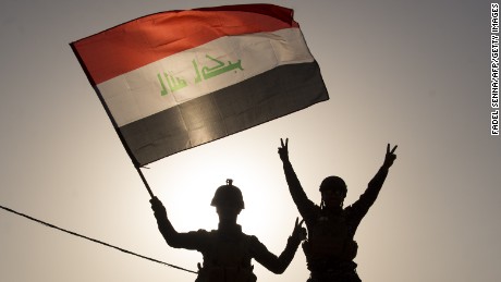 TOPSHOT - Iraq's federal police members wave Iraq's national flag as they celebrate in the Old City of Mosul on July 9, 2017 after the government's announcement of the "liberation" of the embattled city. 
Iraq declared victory against the Islamic State group in Mosul on July 9 after a gruelling months-long campaign, dealing the biggest defeat yet to the jihadist group. / AFP PHOTO / FADEL SENNA        (Photo credit should read FADEL SENNA/AFP/Getty Images)
