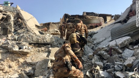 Counter Terror Service (CTS) Troops climb a mound of rubble to reach a house turned fighting position just 50 meters from the Tigris river. They are engaged in fierce clashes to push out ISIS&#39;s remaining pockets of resistance. 