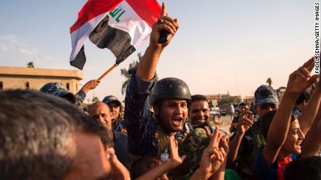 Iraq&#39;s federal police members wave Iraq&#39;s national flag as they celebrate in the Old City of Mosul on July 9, 2017 after the government&#39;s announcement of the &quot;liberation&quot; of the embattled city. Iraq declared victory against the Islamic State group in Mosul on July 9 after a gruelling months-long campaign, dealing the biggest defeat yet to the jihadist group. 