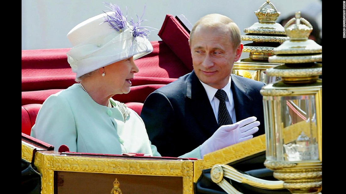 Putin leaves in an open carriage with Britain&#39;s Queen Elizabeth II during a ceremonial welcome in London in June 2003.