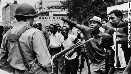 A man gestures with his thumb down to an armed National Guard man, during a protest in Newark, New Jersey, July 14, 1967.