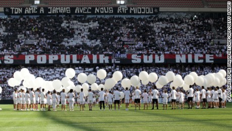 People hold white ballons in the middle of the pitch in tribute to the victims of the Bastille day attack in Nice before the French L1 football match between OGC Nice and Rennes on August 14, 2016, at the Allianz Riviera stadium in Nice, southern France. / AFP / JEAN CHRISTOPHE MAGNENET        (Photo credit should read JEAN CHRISTOPHE MAGNENET/AFP/Getty Images)