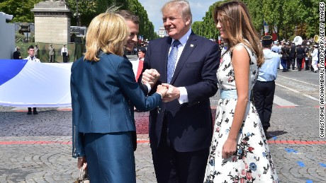 US President Donald Trump (2nd R) shakes hands with French President Emmanuel Macron (2nd L) and his wife Brigitte Macron (L), next to US First Lady Melania Trump, during the annual Bastille Day military parade on the Champs-Elysees avenue in Paris on July 14, 2017.
The parade on Paris&#39;s Champs-Elysees will commemorate the centenary of the US entering WWI and will feature horses, helicopters, planes and troops. / AFP PHOTO / POOL AND AFP PHOTO / CHRISTOPHE ARCHAMBAULT        (Photo credit should read CHRISTOPHE ARCHAMBAULT/AFP/Getty Images)